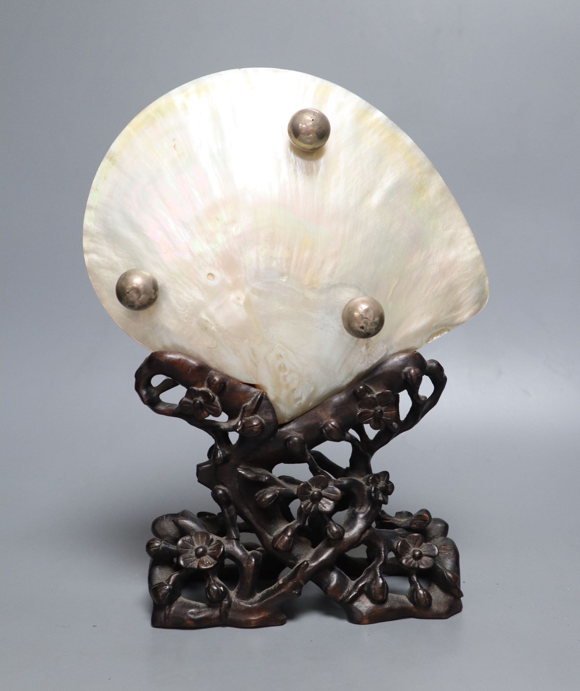 A Chinese mother of pearl shell on wood stand, c.1910